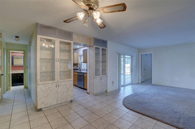 kitchen featuring ceiling fan, dishwasher, light tile patterned floors, and a textured ceiling