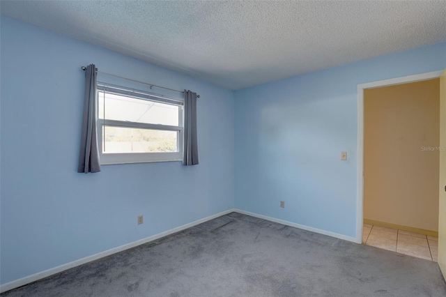 carpeted empty room with a textured ceiling