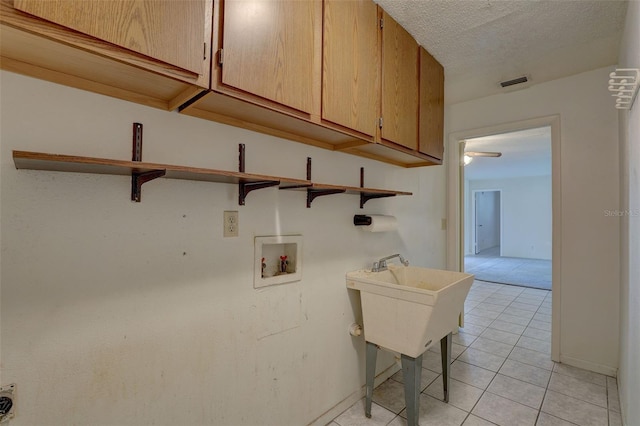 laundry room with cabinets, light tile patterned flooring, and washer hookup