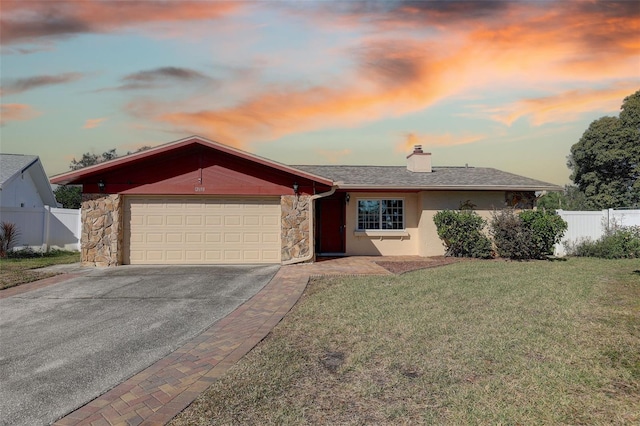 single story home featuring a lawn and a garage