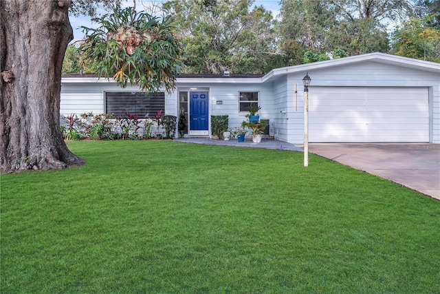 ranch-style home featuring a garage and a front lawn