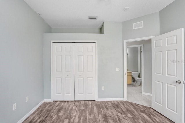 unfurnished bedroom featuring a closet and light wood-type flooring