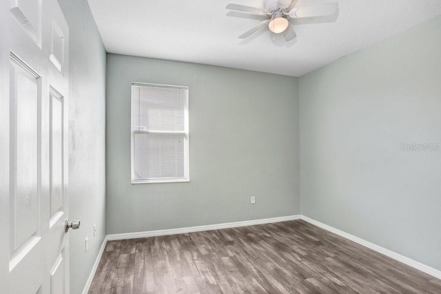 empty room with dark hardwood / wood-style floors and ceiling fan