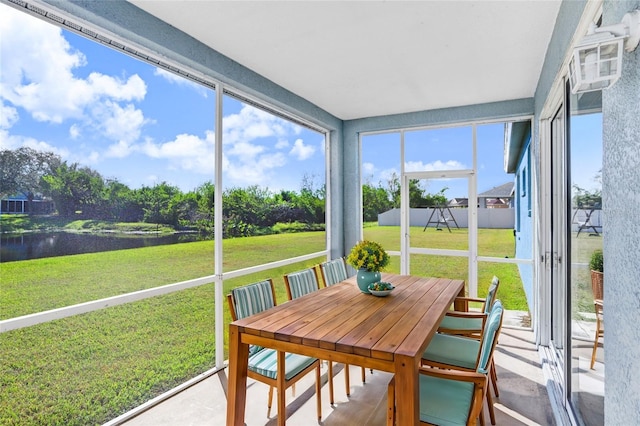 sunroom / solarium featuring a water view