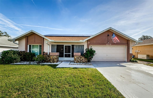 ranch-style house featuring solar panels, cooling unit, a garage, and a front lawn