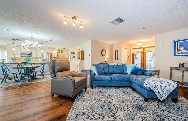 living area featuring a healthy amount of sunlight, visible vents, and wood finished floors