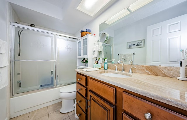 full bathroom featuring toilet, shower / bath combination with glass door, tile patterned flooring, and vanity