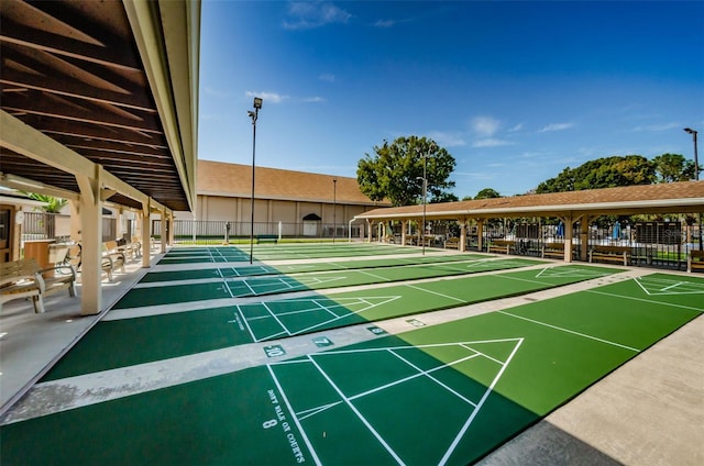 surrounding community with fence and shuffleboard