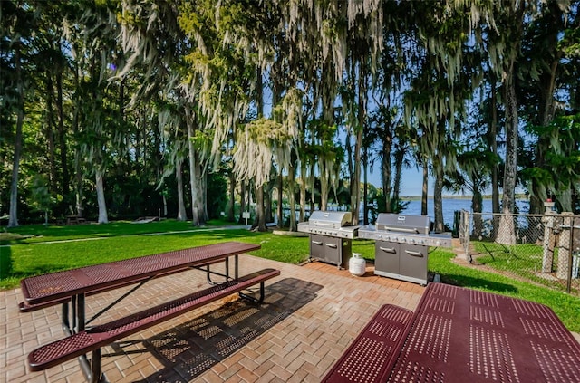 surrounding community featuring a yard, a water view, a patio, and fence