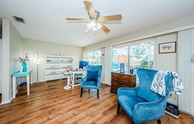 sitting room with visible vents, ceiling fan, a textured ceiling, and wood finished floors