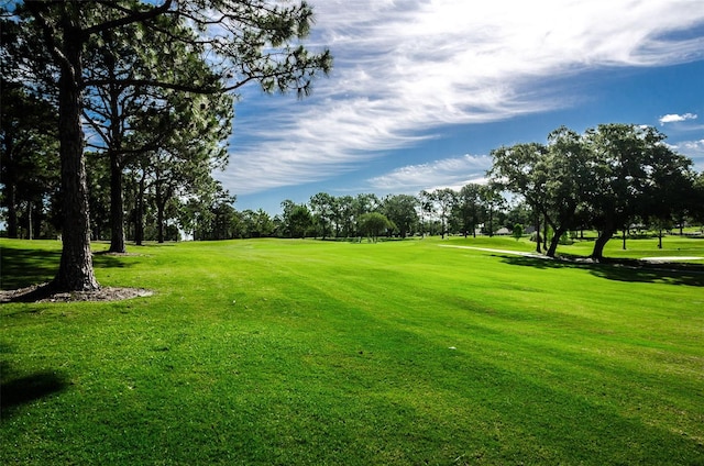 surrounding community featuring view of golf course and a yard