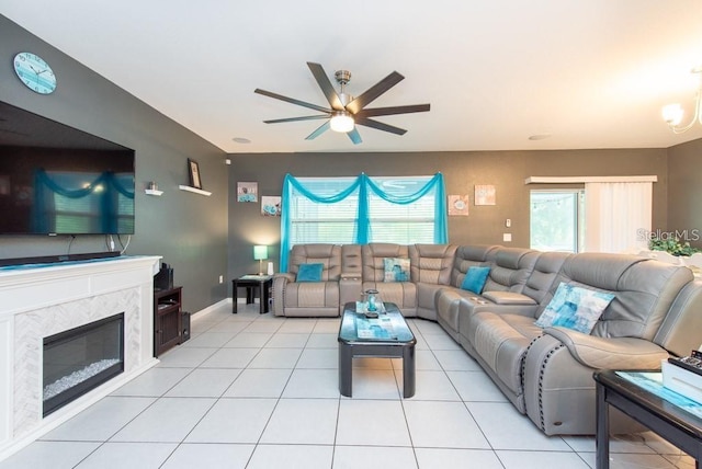 living room featuring ceiling fan, light tile patterned floors, and a fireplace