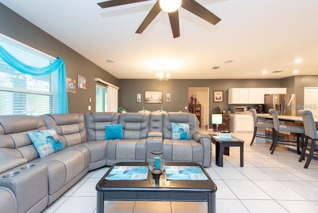 living room with light tile patterned floors and ceiling fan with notable chandelier