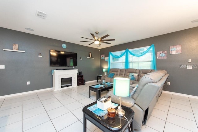 tiled living room with ceiling fan and a premium fireplace