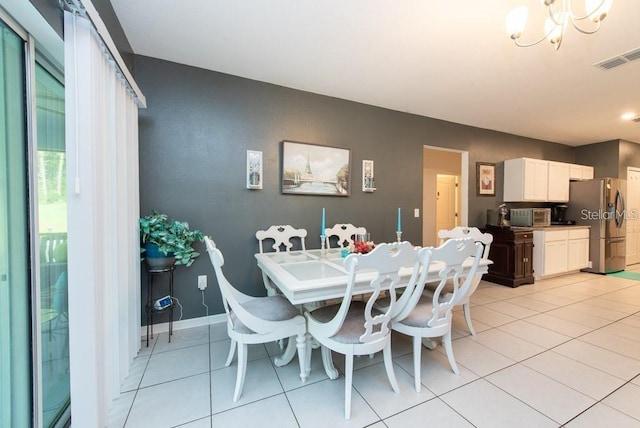 dining space featuring light tile patterned floors and a notable chandelier