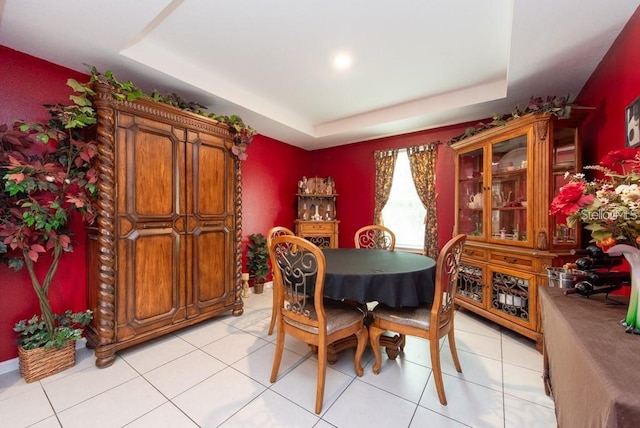 tiled dining area featuring a raised ceiling