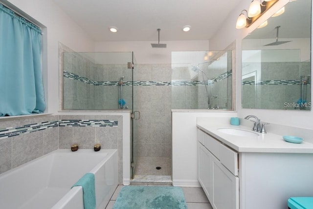 bathroom featuring plus walk in shower, vanity, and tile patterned floors