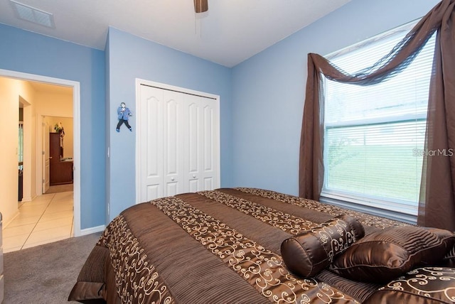 carpeted bedroom featuring ceiling fan and a closet