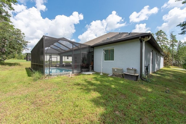 back of property featuring a lawn and a lanai