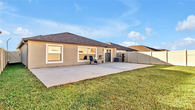 rear view of house with central AC unit, a yard, and a patio