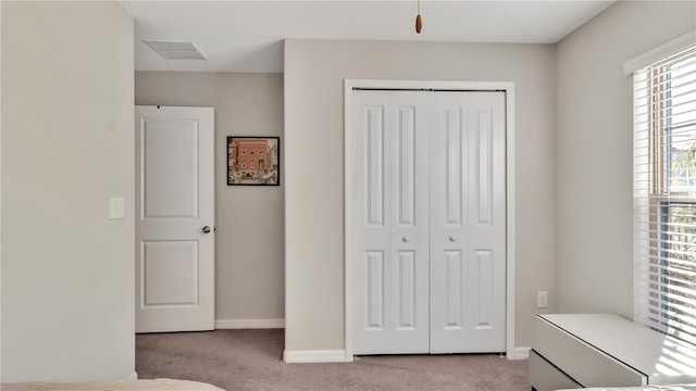 unfurnished bedroom featuring light colored carpet and a closet