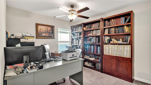 carpeted home office featuring ceiling fan