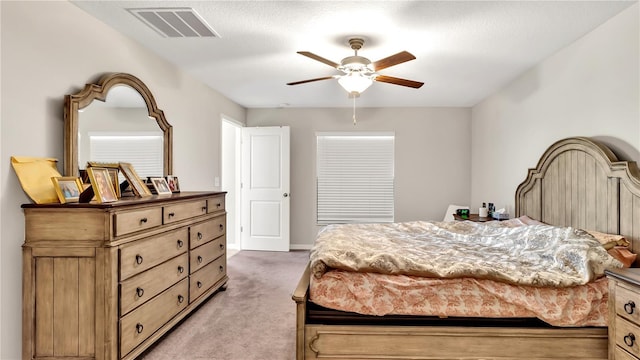 bedroom with light carpet, a textured ceiling, and ceiling fan