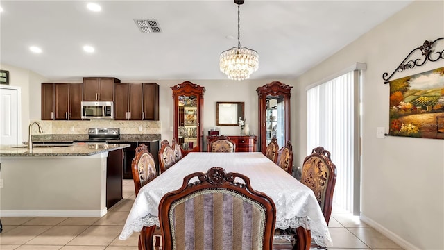 dining room featuring light tile patterned floors, sink, and an inviting chandelier