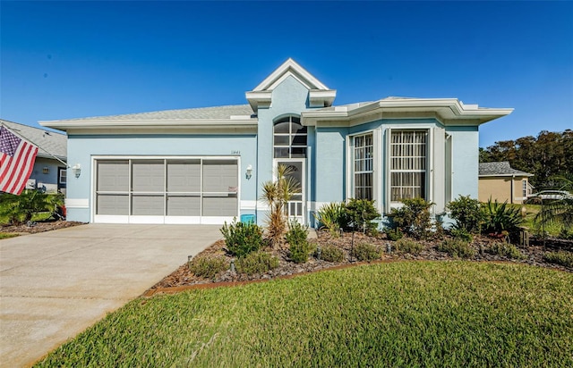 view of front of house featuring a garage and a front lawn