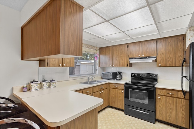 kitchen with kitchen peninsula, a paneled ceiling, sink, and black appliances