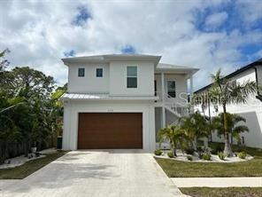 view of front of home featuring metal roof, driveway, an attached garage, and a standing seam roof