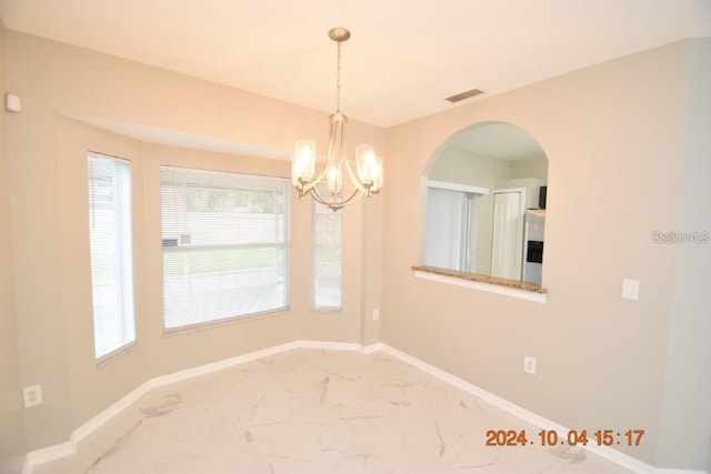 unfurnished dining area with a notable chandelier