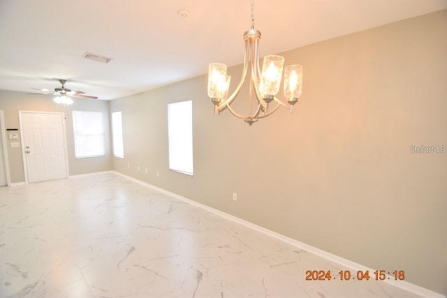 unfurnished room featuring ceiling fan with notable chandelier