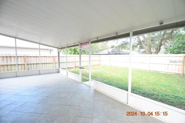 unfurnished sunroom featuring vaulted ceiling