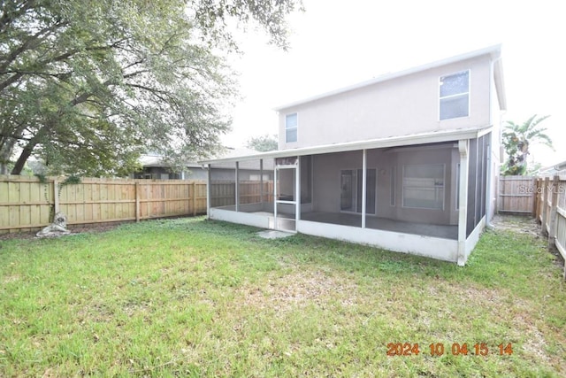 rear view of house with a lawn and a sunroom