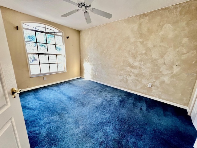 unfurnished room with ceiling fan and carpet