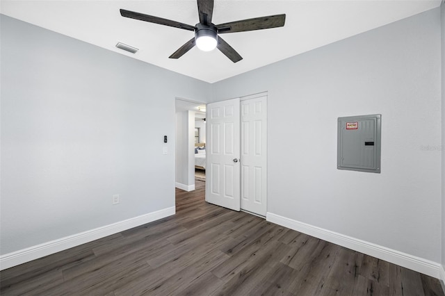 unfurnished bedroom featuring ceiling fan, dark wood-type flooring, and electric panel