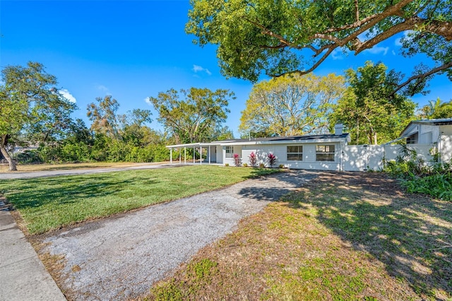 view of front of house featuring a carport and a front lawn