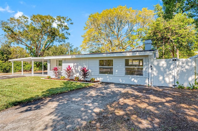 view of front of house with a front yard and a carport