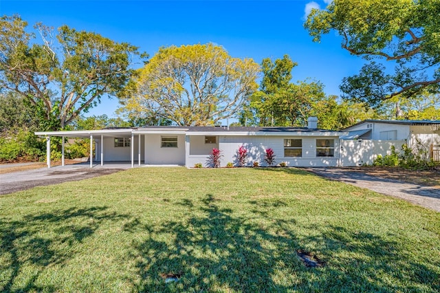 view of front of home with a front yard and a carport