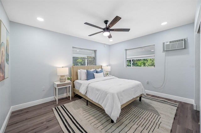 bedroom with a wall mounted air conditioner, dark hardwood / wood-style flooring, and ceiling fan