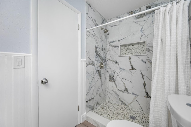 bathroom featuring a shower with curtain and toilet