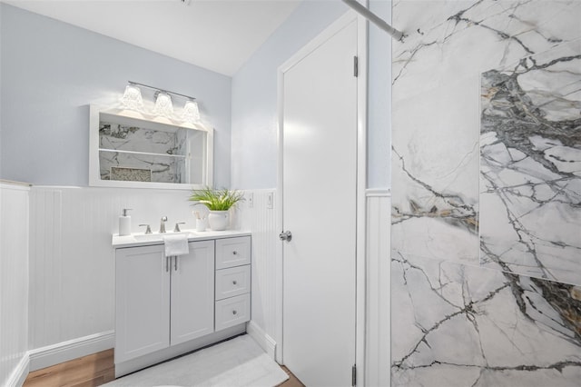 bathroom with a shower, hardwood / wood-style floors, and vanity