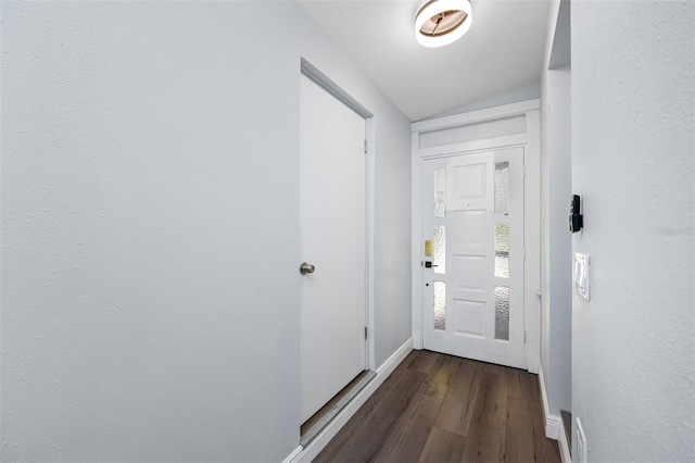 doorway featuring dark hardwood / wood-style floors and vaulted ceiling