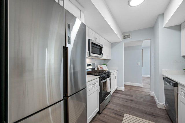 kitchen with white cabinetry, dark wood-type flooring, and stainless steel appliances