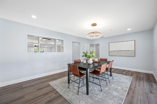 dining area featuring hardwood / wood-style flooring and ceiling fan with notable chandelier