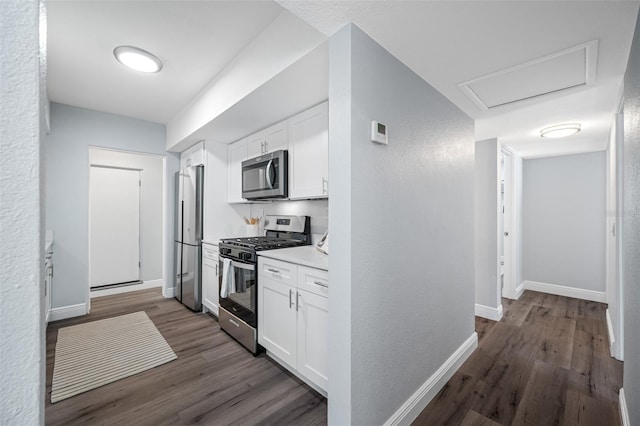 kitchen featuring dark hardwood / wood-style flooring, white cabinets, and appliances with stainless steel finishes