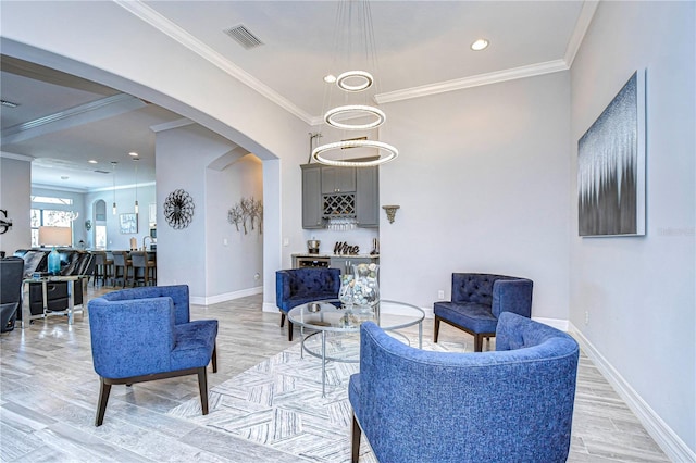 living area featuring bar area, crown molding, and hardwood / wood-style floors