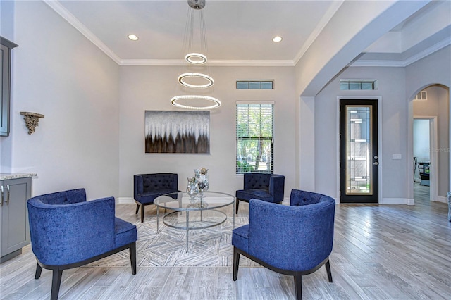 sitting room featuring light wood-type flooring and crown molding