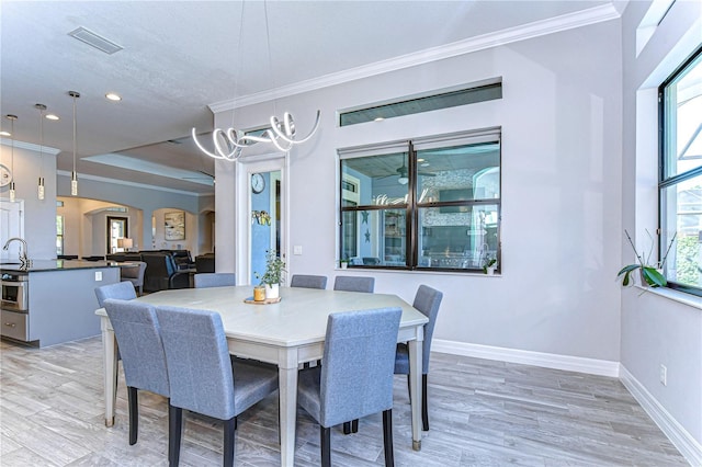 dining space featuring light wood-type flooring and crown molding